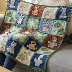 May include: A handmade crochet blanket with a patchwork design. The squares are in shades of blue, green, and beige, each adorned with an embroidered animal or leaf motif. The blanket is displayed, highlighting the craftsmanship and the variety of colors.