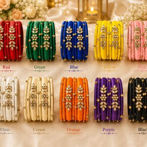 May include: Ten sets of silk thread bangles in red, green, blue, yellow, pink, white, cream, orange, purple, and black. Each set features a central band adorned with clear crystal floral and leaf motifs, flanked by plain matching bangles.