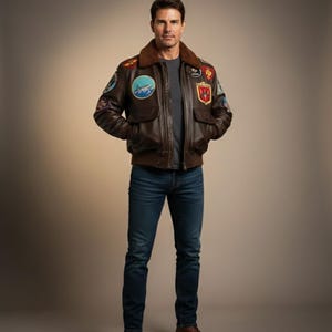 Könnte beinhalten: Braune Leder-Bomberjacke mit mehreren Aufnähern, einem braunen Fellkragen und zwei Vordertaschen. Die Jacke wird mit einem grauen Hemd und einer blauen Jeans kombiniert. Die Jacke hat einen Reißverschluss.