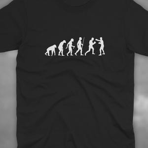 May include: Black t-shirt featuring a white graphic depicting the evolution of man, culminating in two figures boxing. The shirt has a crew neck and short sleeves. The text "HIGHLIGHT SPORTS" is printed in white on the bottom right.