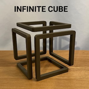 May include: A brown, geometric sculpture in the shape of an infinite cube. The sculpture is made of square frames that intersect to create the illusion of a continuous form. The text "INFINITE CUBE" is above the sculpture.