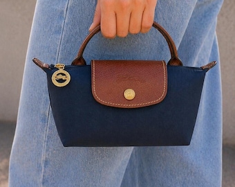 Bolso bandolera mini azul marino de Longchamp con correa de hombro desmontable.