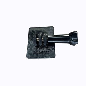 Peut inclure: Support de caméra noir avec une base rectangulaire et un bras cylindrique. La base a une surface texturée et le mot "SEMIJO" est imprimé dessus. Le bras a une extrémité incurvée.