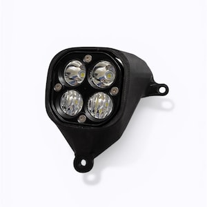 May include: A black automotive LED headlight assembly featuring four circular light lenses arranged in a square pattern within a matte black housing. The unit includes integrated mounting tabs with circular holes for secure installation.
