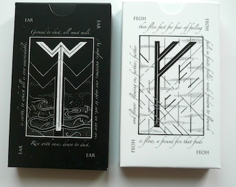 May include: Two black and white playing cards with a rune symbol on each card. The card on the left has the rune Ear and the text "Ground to dust, all must mell. Rise with case, down to dust." The card on the right has the rune Feoh and the text "then flies fast for fear of failing is flow, a fecund fire that feeds."