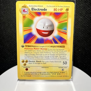 May include: A yellow Electrode trading card from the 1999 Wizards of the Coast set. The card features a 1st Edition stamp, 80 HP, and the Electric Shock attack. It displays the character Electrode with a red and white body against a rainbow background.