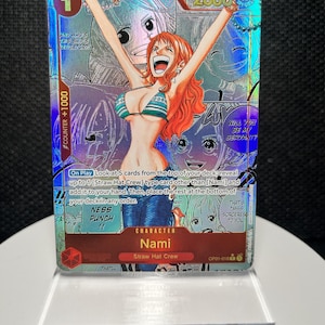 May include: A holographic One Piece trading card featuring the character Nami with orange hair, wearing a striped bikini top and blue jeans, with arms raised. The card includes game text, a power level of 2000, and a counter value of +1000.