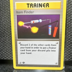 May include: A yellow Trainer card labeled "Item Finder." The card features an illustration of a device with glowing orbs and text that reads, "Discard 2 of the other cards from your hand in order to put a Trainer card from your discard pile into your hand."