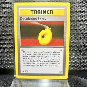 Può includere: Una carta Allenatore Pokémon intitolata "Devolution Spray". La carta presenta un'illustrazione gialla e rossa di un flacone spray. Il testo della carta descrive l'effetto dello spray sullo stadio evolutivo di un Pokémon.