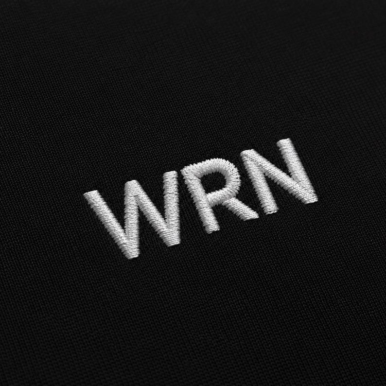 May include: Close-up of black fabric with the embroidered letters "WRN" in white. The letters are in a sans-serif font and are evenly spaced. The fabric has a subtle texture.