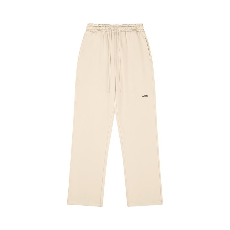 Pale beige sweatpants with a drawstring waist and a loose fit. The trousers feature a small "WRN" logo near the left pocket. The material looks soft and lightweight, ideal for casual wear.