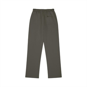 Puede incluir: Pantalones de ch&aacute;ndal de color verde oliva oscuro s&oacute;lido con cintura el&aacute;stica sin cord&oacute;n y un bolsillo de parche &uacute;nico situado en la parte superior derecha de la parte trasera. Los pantalones tienen un corte recto y un acabado liso sin estampados.