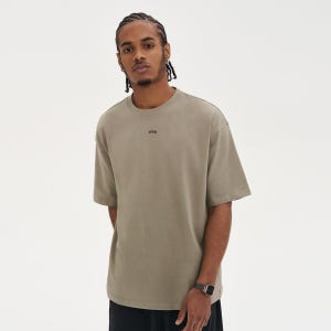 May include: A short-sleeved, olive green t-shirt with the word "WRN" printed in black on the chest. The shirt has a crew neck and a relaxed fit. The person is wearing a watch with a silver band.