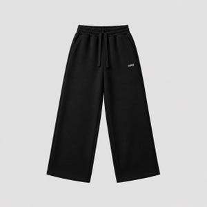 Puede incluir: Pantalones de ch&aacute;ndal negros con silueta de pierna ancha, cintura el&aacute;stica con cord&oacute;n a juego y dos bolsillos laterales. El texto WRN est&aacute; impreso en letras blancas peque&ntilde;as en la parte superior del muslo izquierdo de la prenda.
