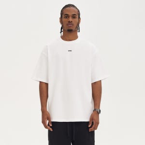 May include: A white t-shirt with short sleeves and a crew neck. The word "WRN" is printed in black on the chest. The model is wearing a watch and black pants. The background is plain white.