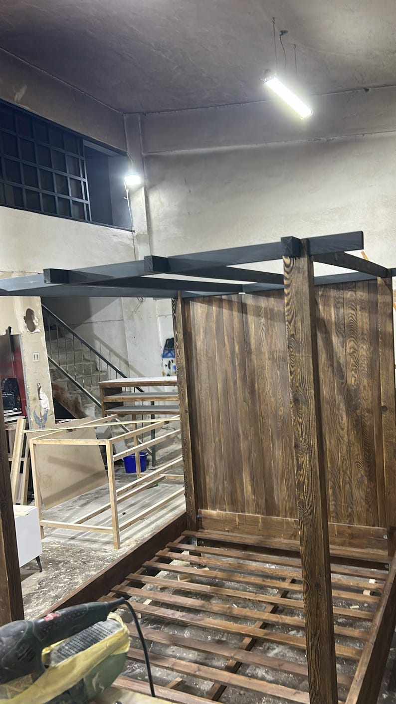 Close-up of wooden canopy bed post and handcrafted joinery showing the substantial solid wood construction