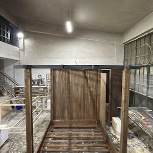 Close-up of solid wood bed frame showing natural wood grain, texture and handcrafted rustic finish