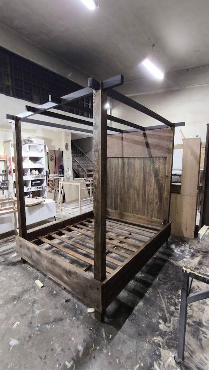 Front view of a rustic canopy bed handcrafted from solid wood with tall four poster frame and natural wood grain