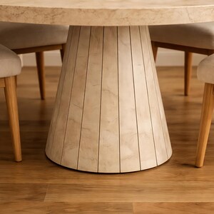 Close-up detail of fluted pedestal table base with travertine stone look finish and tapered round design