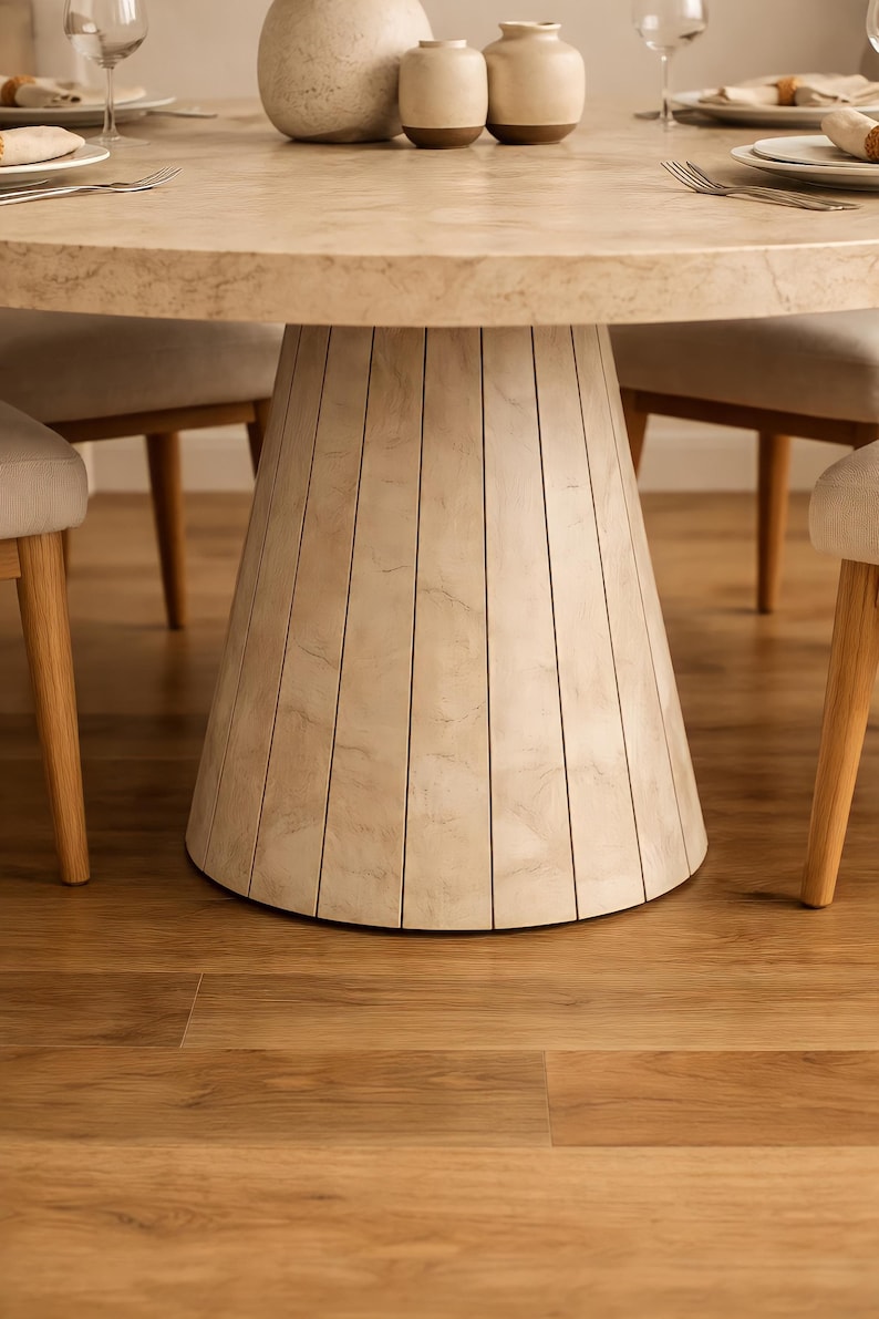 Close-up detail of fluted pedestal table base with travertine stone look finish and tapered round design
