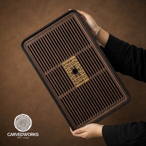 May include: A rectangular dark brown wooden tea tray featuring a slatted surface design for drainage. The centre of the tray displays an intricate, light-coloured rectangular inlay with a geometric pattern and a circular cutout in the middle.