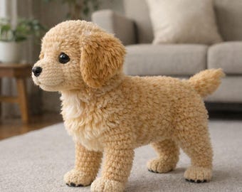 May include: A crocheted golden retriever puppy with a fluffy, textured appearance. The dog has black eyes and a black nose, with a light tan color. The puppy is standing on a light gray carpet.