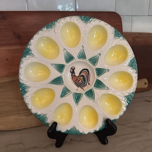 May include: A set of three ceramic mugs with a speckled, matte finish. Each mug features a different color: light blue, cream, and gray. The mugs have a simple, modern design and a comfortable handle.