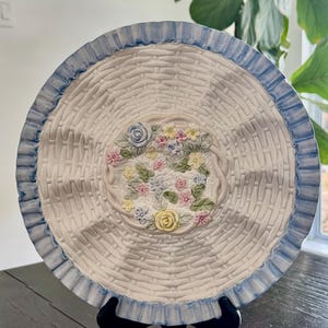 May include: A white ceramic mug with a black handle and the text "But First, Coffee" in a handwritten style. The mug is on a white surface. The mug is 4 inches tall.