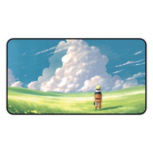 Peut inclure: Tapis de souris rectangulaire avec une illustration de style anime. Le design présente un personnage en tenue orange et noire debout dans un champ vert, avec un grand nuage en arrière-plan sous un ciel bleu.