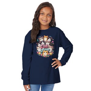 Könnte beinhalten: Marineblaues Langarmshirt mit einem farbenfrohen Grafikdesign verschiedener Katzen, die in einem Kreis angeordnet sind, mit den Worten "Cat Love" in der Mitte. Das Design umfasst Blumen und dekorative Elemente und schafft eine verspielte und skurrile Ästhetik.
