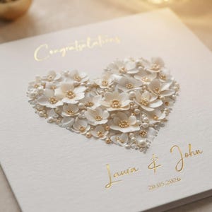Close-up macro shot highlighting the foil finish and delicate white floral heart texture on the greeting card.