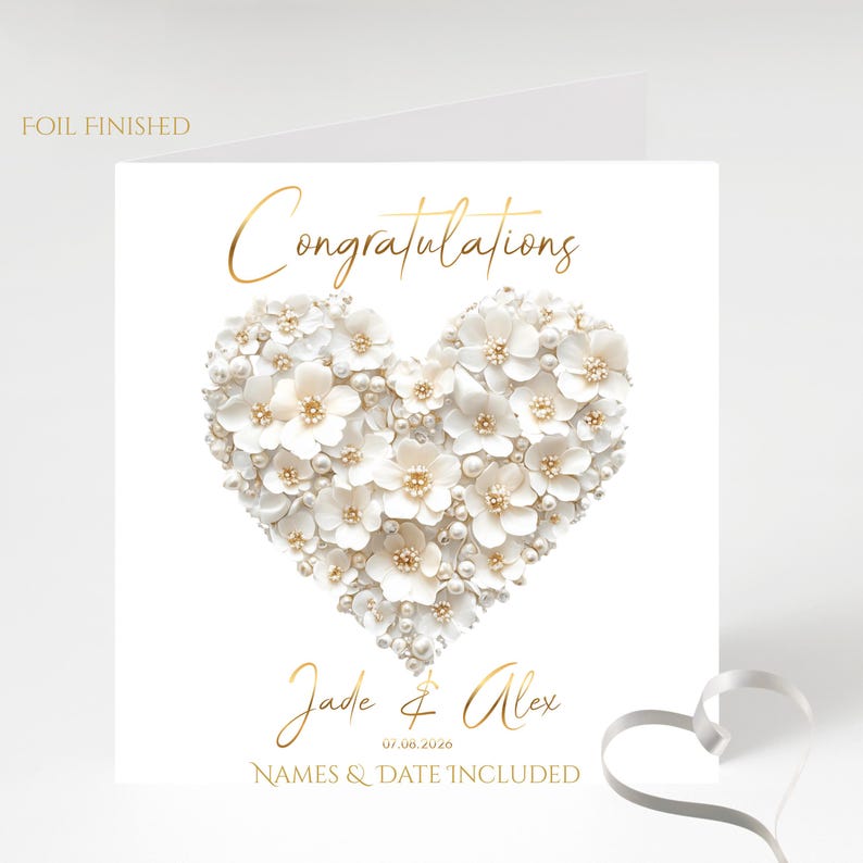 A white square card with a gold foil border and the words "FOIL FINISHED" in the top left corner, featuring a heart shape made of white flowers and pearls, with "Congratulations" in gold foil above and "Jade & Alex" and "07.08.2026" and "NAMES &