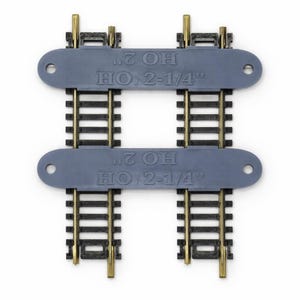 Op de afbeelding: Twee HO-schaal modeltreinbaanstukken. Elke sectie heeft zwarte rails met messingkleurige connectoren en een grijze plastic basis. De tekst "HO 2" en "HO 2-1/4" is gedrukt op de grijze basis.