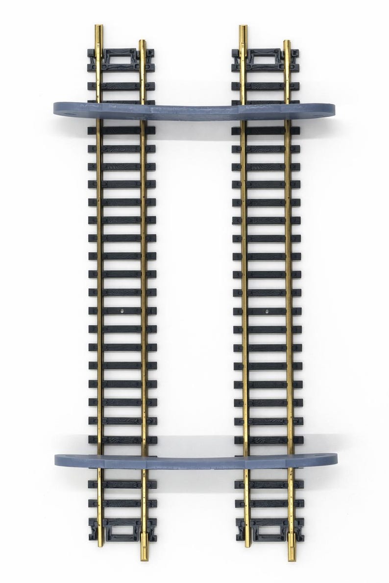 Op de afbeelding: Twee modelspoorwegplanken. Elke plank heeft zwarte rails met goudkleurige rails en een gebogen, lichtblauwe plank. De planken zijn op een witte achtergrond gemonteerd.