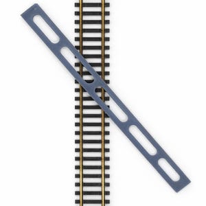 Op de afbeelding: Een close-up van modeltreinrails met een grijze plastic spooruitlijningsgereedschap. De rails zijn zwart met goudkleurige rails. Het uitlijningsgereedschap is een lang, dun stuk met twee grote ovale uitsparingen.