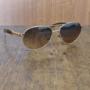 Puede incluir: Una taza de cerámica blanca con un asa negra y el texto "But First, Coffee" en negro, con una fuente de estilo manuscrito. La taza está sobre una superficie blanca.