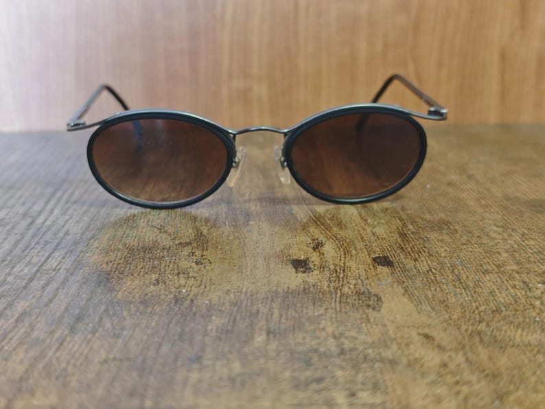 May include: A white ceramic mug with a black handle and the text "But First, Coffee" in a handwritten style. The mug is on a white surface. The mug is 4 inches tall.