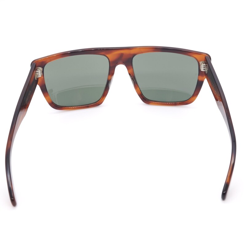 May include: Sunglasses with a tortoiseshell pattern frame and green lenses. The sunglasses have a rectangular shape and a classic design. The arms are dark brown and extend outward. The sunglasses are viewed from the inside.