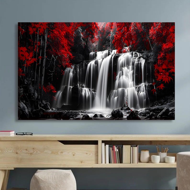 May include: A black and white canvas print of a waterfall cascading over rocks. The image is accented with vibrant red foliage, creating a striking contrast. The artwork is displayed on a light wood console table.