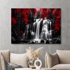 May include: A black and white canvas print of a waterfall cascading over rocks. The image is accented with vibrant red foliage, creating a striking contrast. The artwork is displayed on a gray wall.