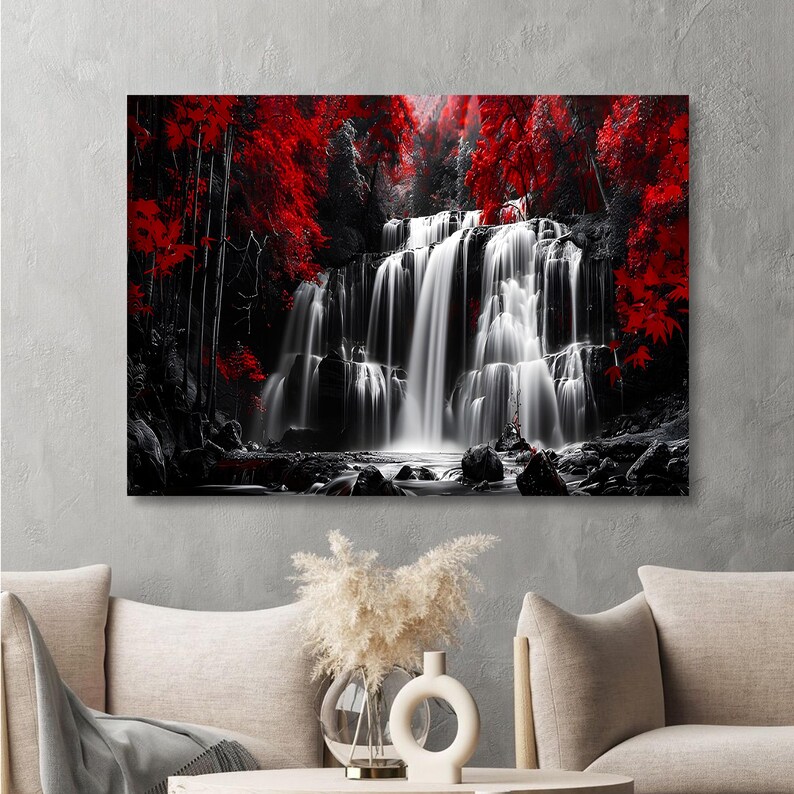 May include: A black and white canvas print of a waterfall cascading over rocks. The image is accented with vibrant red foliage, creating a striking contrast. The artwork is displayed on a gray wall.