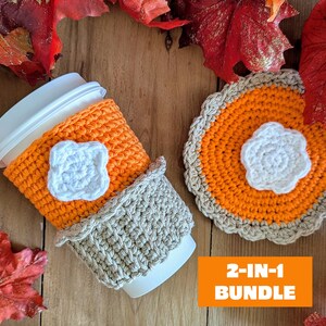 May include: An orange and white crochet coffee cup cozy and matching coaster set. The cozy has a white floral accent and a gray trim. The coaster is pie-shaped with a white floral accent. The image includes the text "2-IN-1 BUNDLE".
