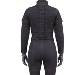 May include: Black jacket and pants set. The jacket has a high collar and a cropped design. The pants are fitted with visible stitching. The outfit is displayed on a mannequin.