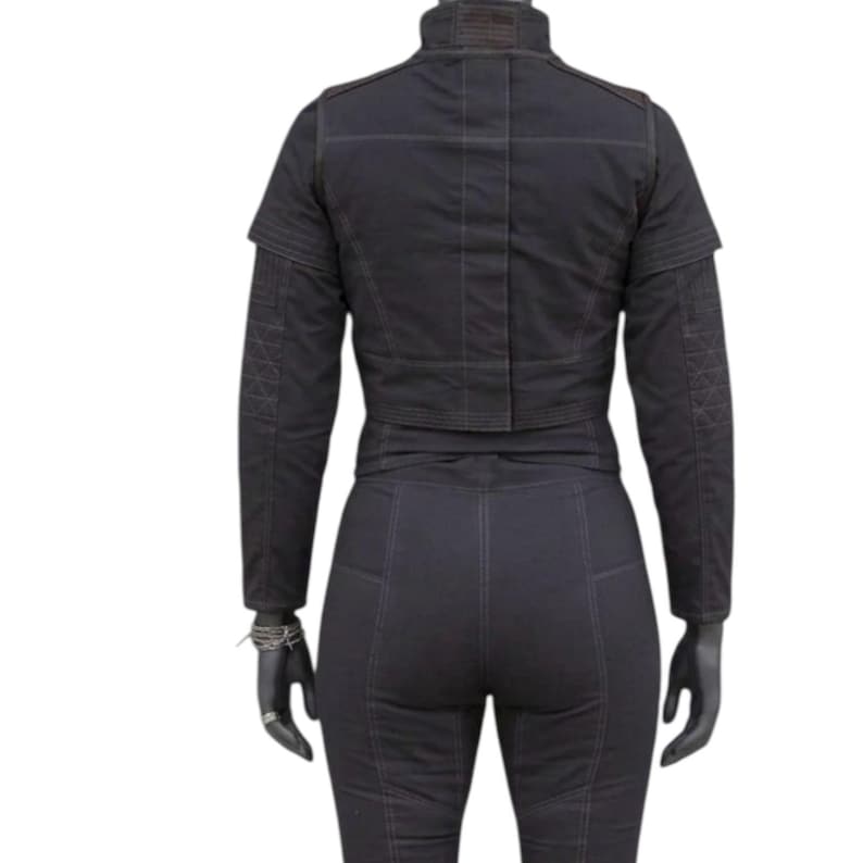 May include: Black jacket and pants set. The jacket has a high collar and a cropped design. The pants are fitted with visible stitching. The outfit is displayed on a mannequin.