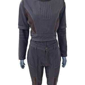 K&ouml;nnte beinhalten: Ein dunkelgraues zweiteiliges Outfit mit wei&szlig;en N&auml;hten. Das Oberteil hat einen hohen Kragen und lange &Auml;rmel. Die Hose hat einen Knopfverschluss und Taschen. Das Outfit wird auf einer Schaufensterpuppe pr&auml;sentiert.