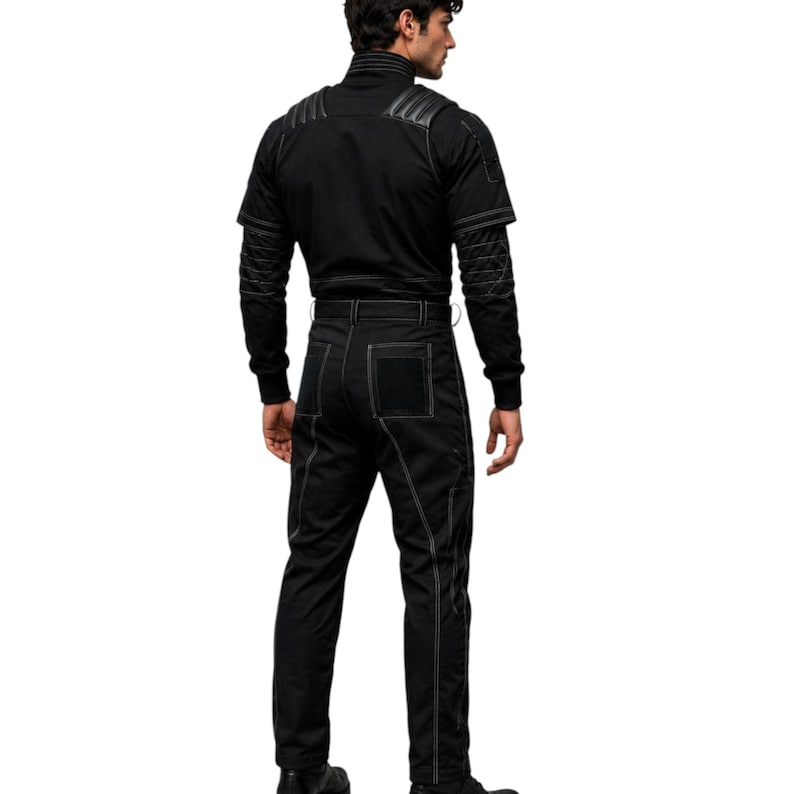 K&ouml;nnte beinhalten: Schwarzer Overall mit wei&szlig;en Steppn&auml;hten. Das Outfit hat einen hohen Kragen, lange &Auml;rmel und eine taillierte Passform. Die Hose hat eine quadratische Tasche auf der R&uuml;ckseite. Die N&auml;hte erzeugen ein kontrastreiches Design.