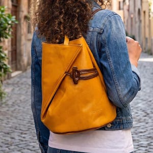 Sac à dos convertible en cuir italien fait main, jaune moutarde, design asymétrique avec fermeture à nœud