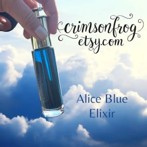 May include: A clear glass bottle with a silver and gold cap, filled with a vibrant blue liquid. The bottle is held against a backdrop of a cloudy sky. Text on the image reads "crimsonfrog etsy.com" and "Alice Blue Elixir".