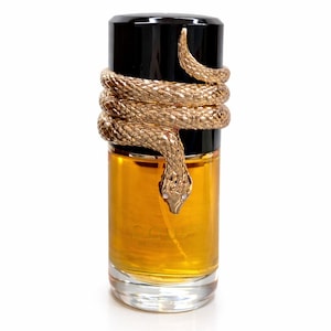 May include: A perfume bottle with a black cap and a gold-colored snake wrapped around it. The perfume inside is amber-colored, and the bottle is clear. The snake's head is at the front of the bottle.