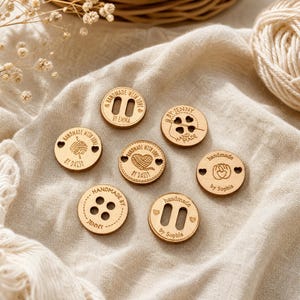 May include: Seven circular light brown wooden buttons with engraved designs and text. The buttons feature various icons including yarn balls, needles, and hands, along with personalised text such as Handmade with love by Emma, Daisy, Jenny, and Sophia.